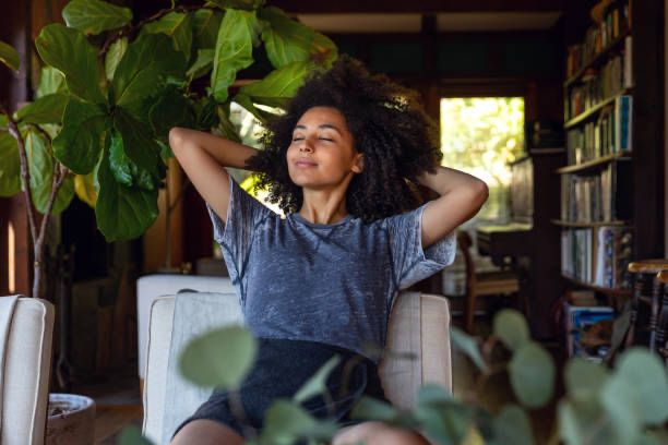 African american woman relaxing on a porch filled with plants. This is the hero image of a health and wellness blog by Palton Morgan, the leading luxury real estate company in Lagos, Nigeria